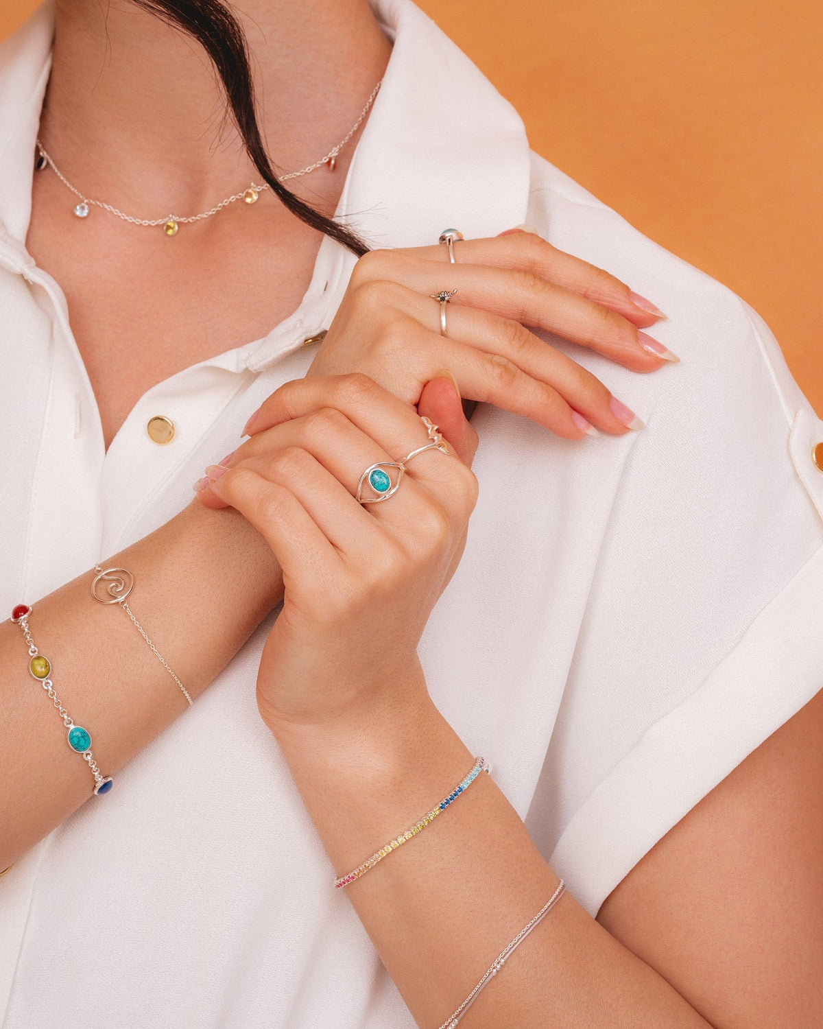 Dainty sterling silver chain bracelet with grey cord and fixed silver ball accents worn on a model's wrist.