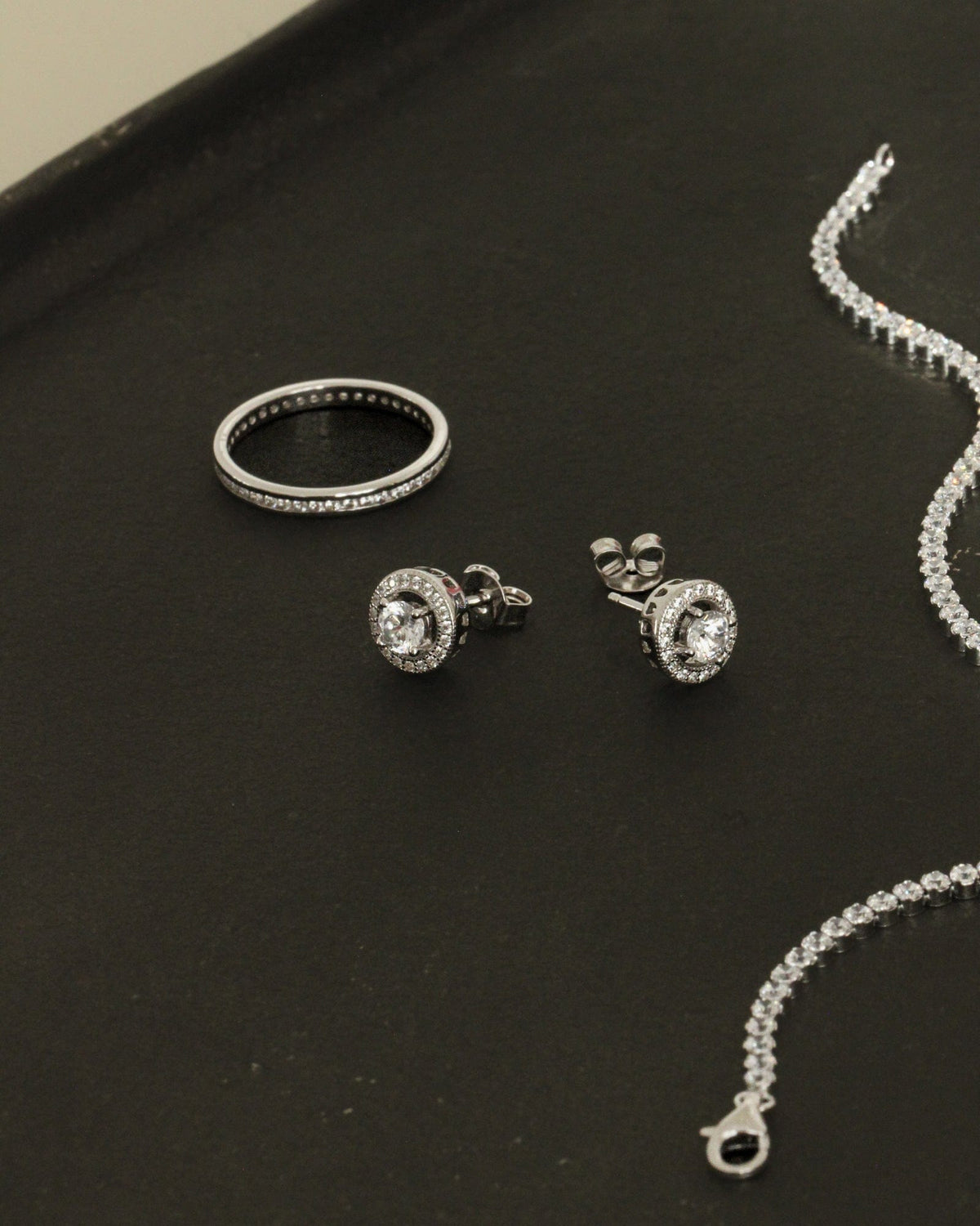 Rhodium-plated sterling silver round stud earrings featuring a central claw-set cubic zirconia surrounded by micro-set stones.