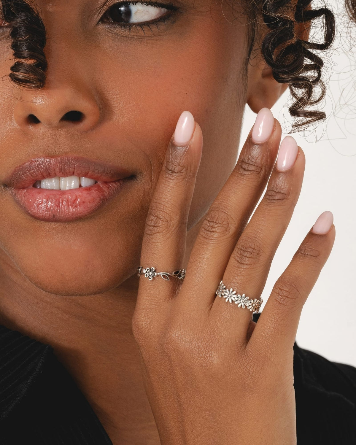Sterling silver daisy chain ring worn on a finger, featuring a delicate floral design for everyday feminine style.
