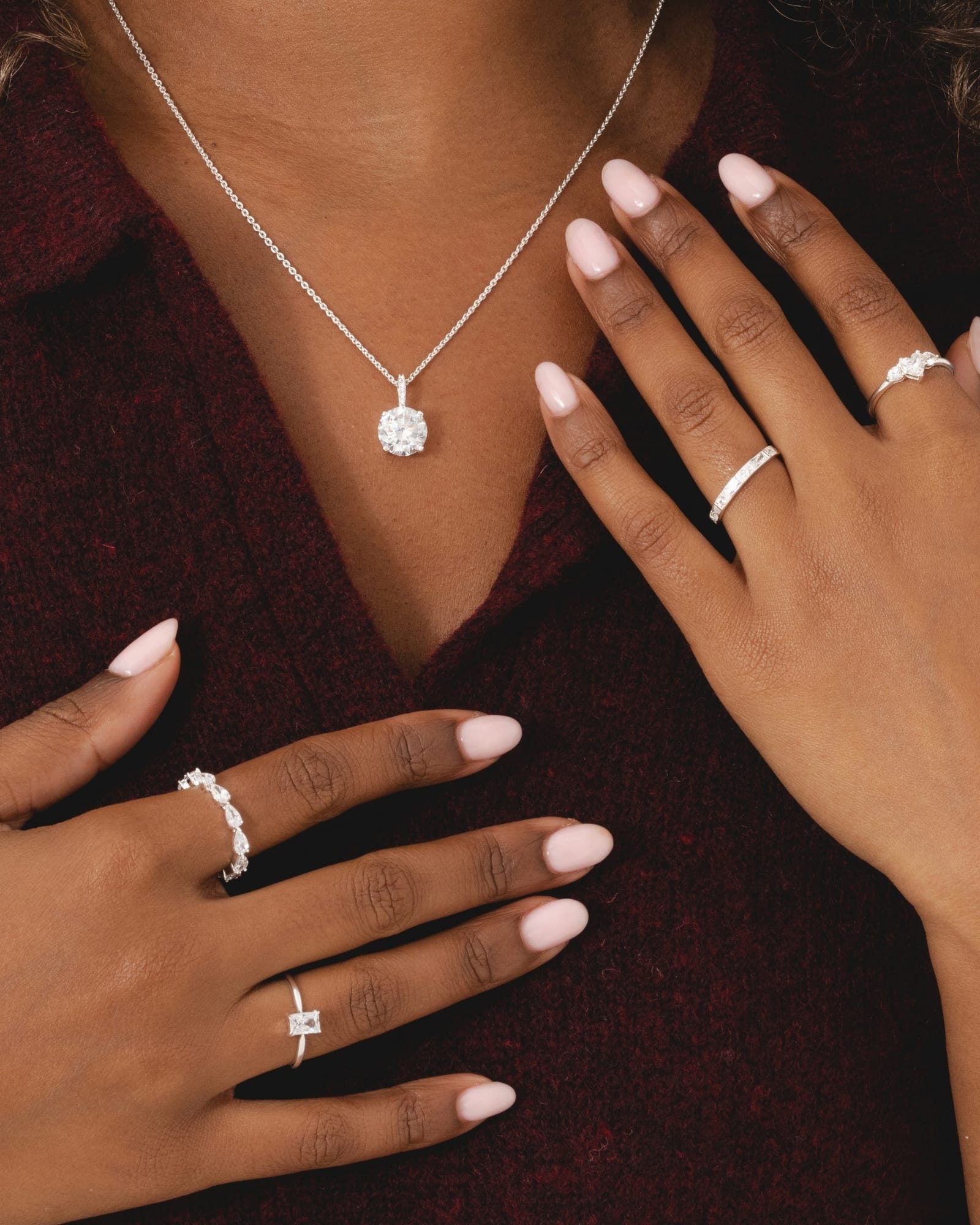 Sterling silver emerald-cut cubic zirconia solitaire ring worn with stacked silver bands and a matching pendant necklace.