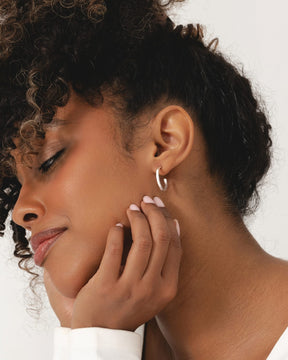 Model wearing 20mm square tube hoop earrings crafted from polished sterling silver.