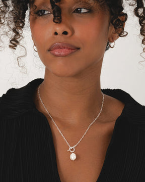 Sterling silver oval link chain necklace featuring a modern T-bar clasp and a single ivory freshwater pearl pendant.