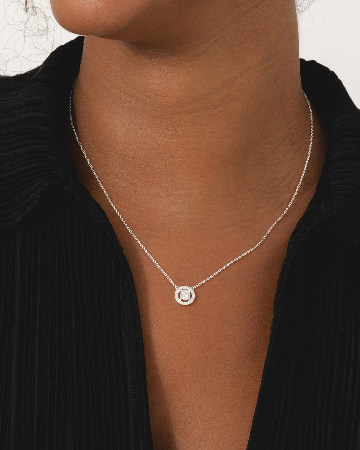 Sterling silver necklace featuring a circular cubic zirconia halo pendant on a delicate fine chain.