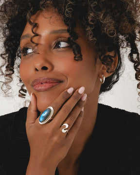 Model wearing a sterling silver chunky wiggle ring with a 3D wave design on a slim band.
