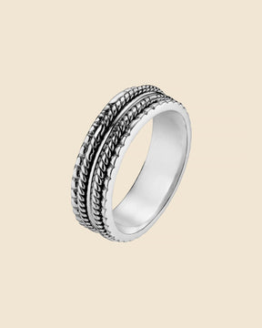 Handcrafted sterling silver spinning ring with textured rope-style bands and an oxidized finish on a polished base.