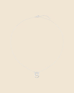 Sterling silver necklace with two interlinking circles, one polished and one set with sparkling cubic zirconia stones.