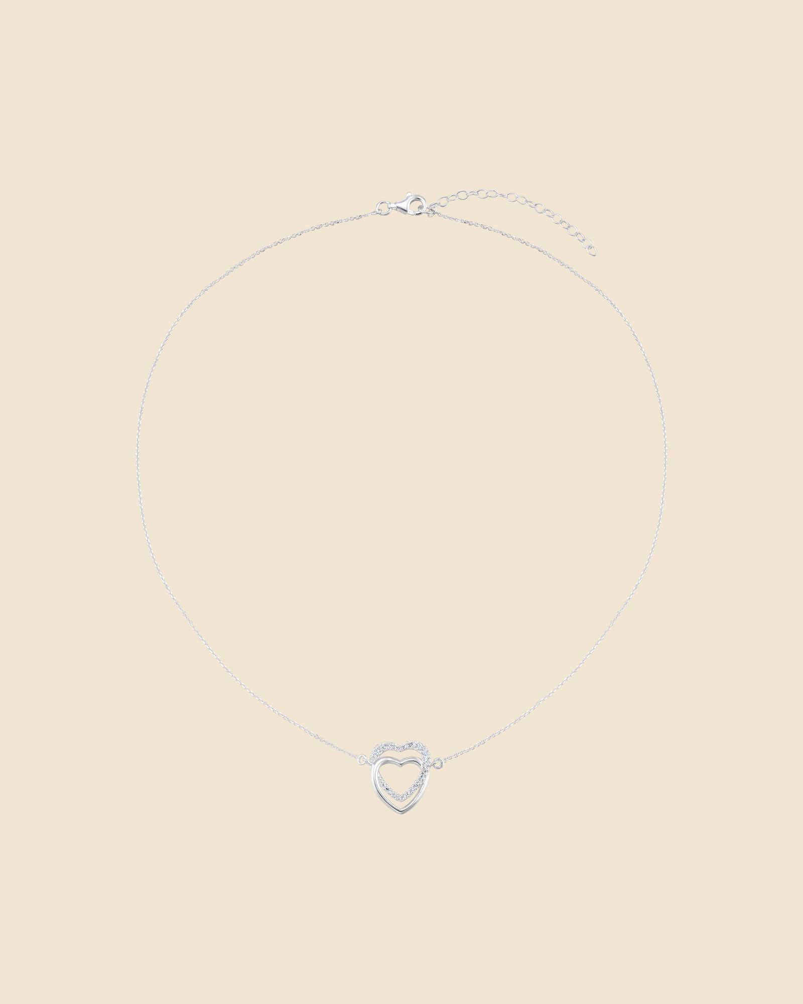 Sterling silver necklace with two interlinked hearts, one polished and one accented with sparkling cubic zirconia.