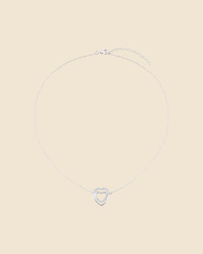 Sterling silver necklace with two interlinked hearts, one polished and one accented with sparkling cubic zirconia.
