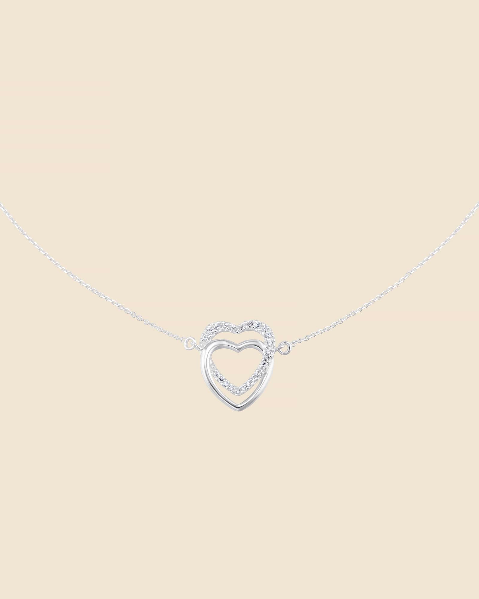 Sterling silver necklace with two interlinked hearts, one polished silver and one accented with sparkling cubic zirconia.