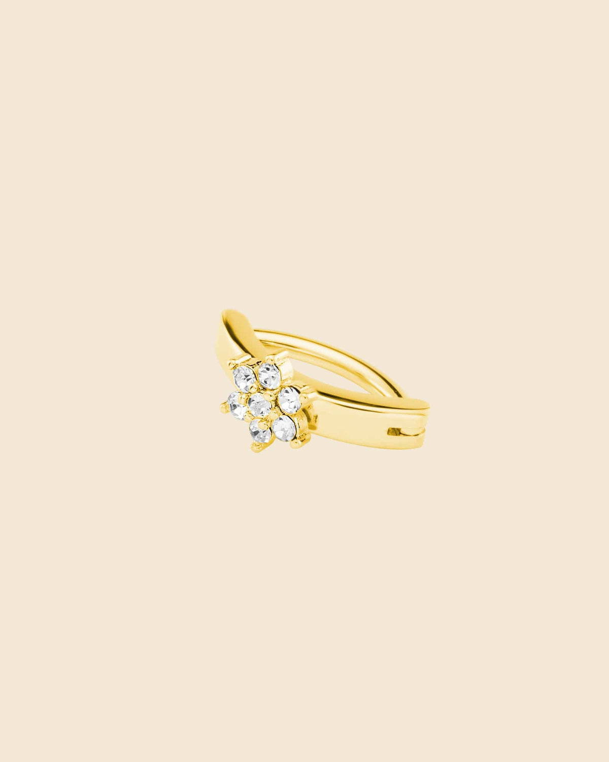 Gold-tone curved navel clicker ring featuring a sparkling cubic zirconia flower design on a smooth metal band.