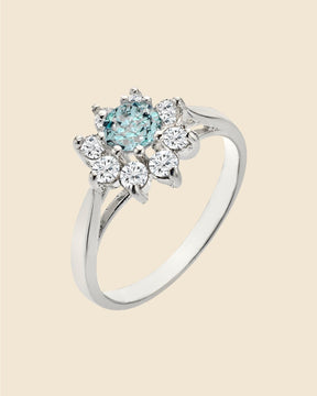 Sterling silver cluster ring featuring a central blue topaz surrounded by sparkling cubic zirconia stones.